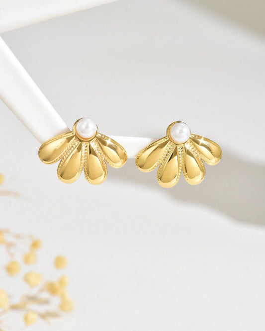 Gold earrings with pearl centers on a white background