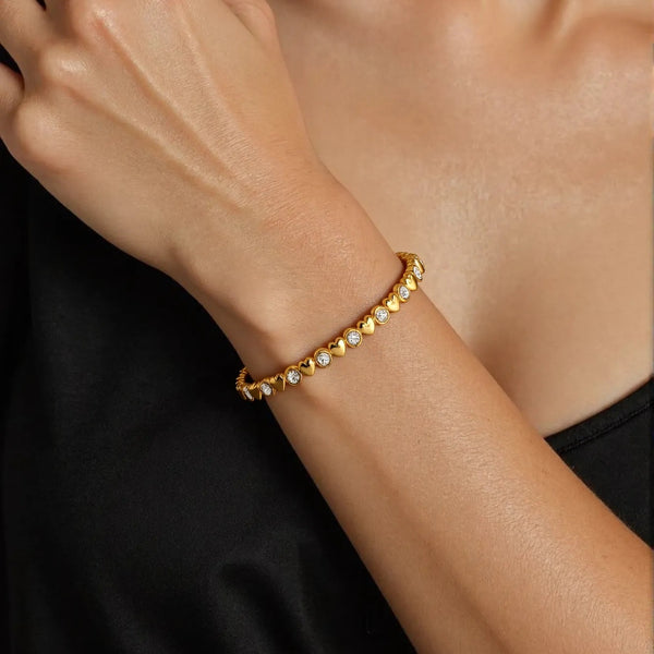 Gold bracelet on a person's wrist with a blurred background