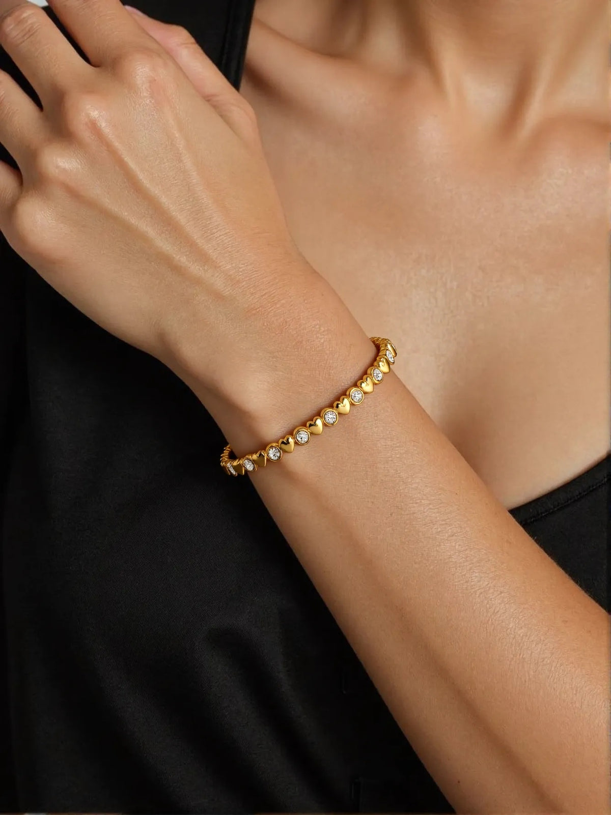 Gold bracelet on a person's wrist with a blurred background